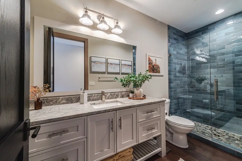 Completed modern bathroom remodel by Avid Builders with black-framed mirrors and a skylight